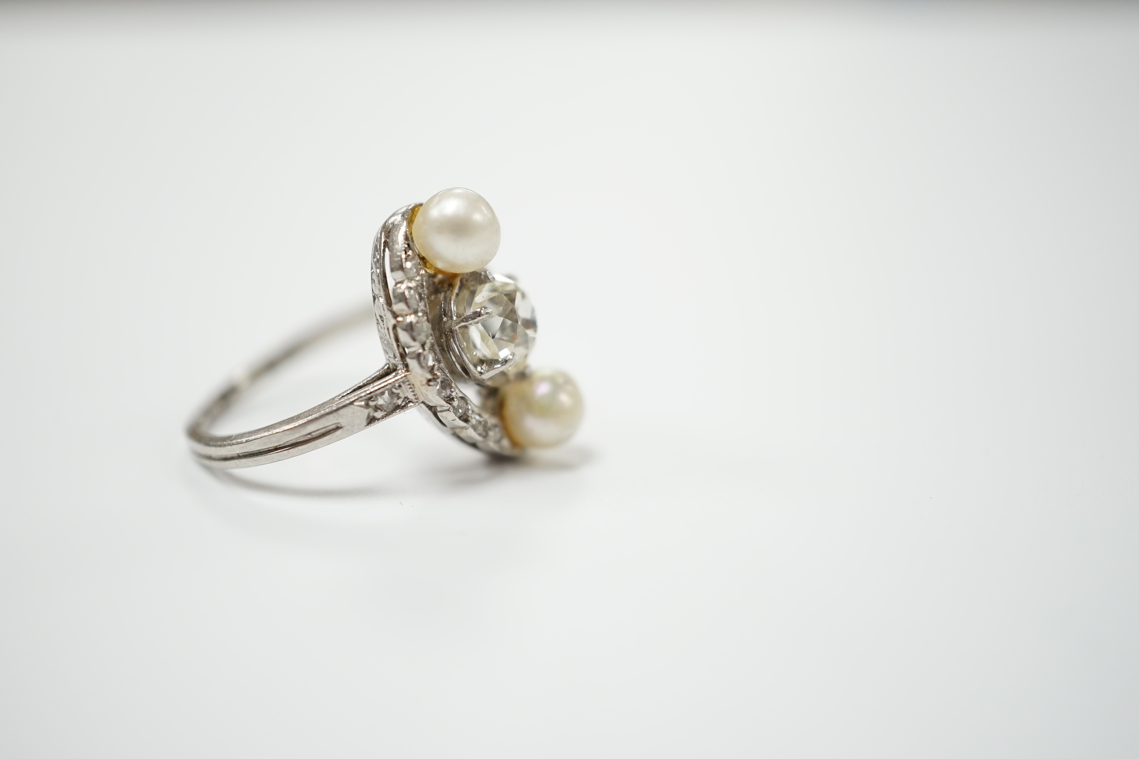 A white metal single stone diamond and two stone cultured pearl set elliptical shaped ring, size F, gross weight 4.3 grams.